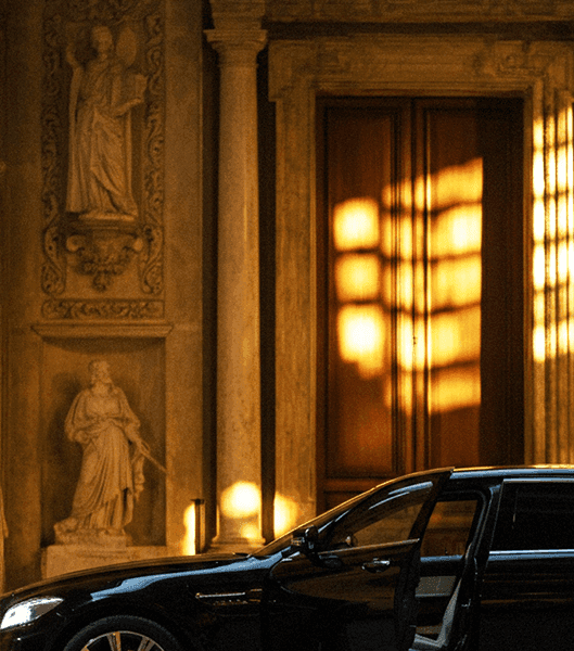 автомобиль у здания в Риме с вечерним светом и архитектурой