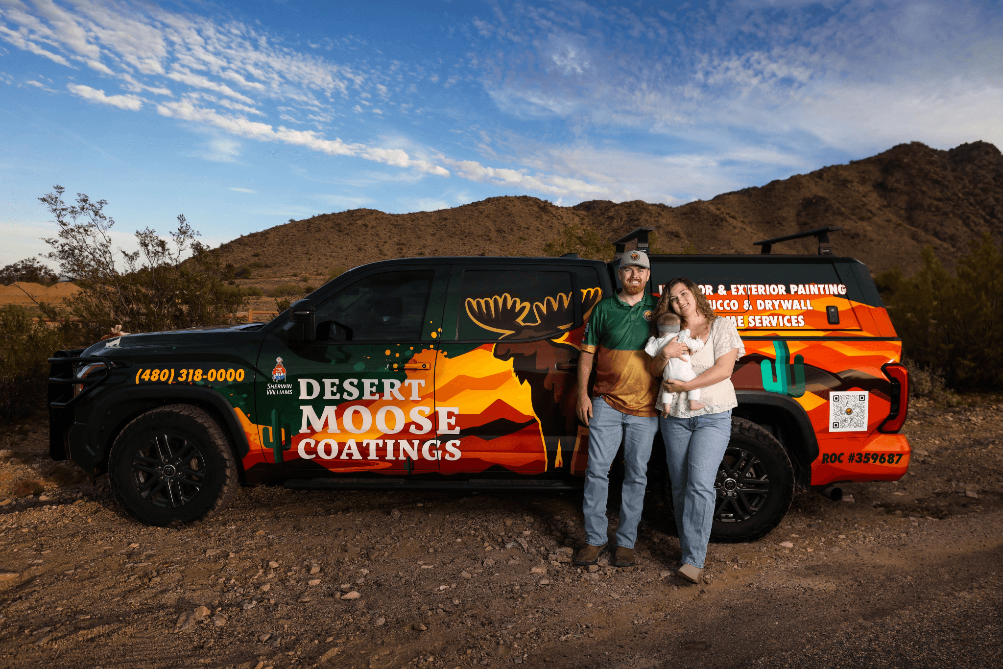 Family-owned Desert Moose Coatings team stands beside branded service truck in Arizona desert landscape.
