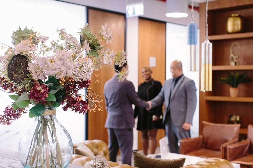 رجل أعمال يصافح عميلاً في صالة استقبال أنيقة للحصول على رخصة دائرة التنمية الاقتصادية دبي.