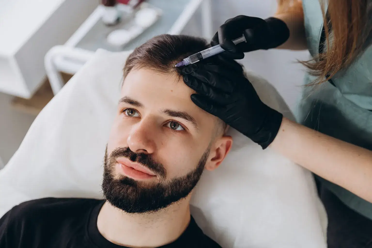 Man receiving PRP hair restoration treatment, where plasma is injected into the scalp to stimulate natural hair growth and improve thickness.
