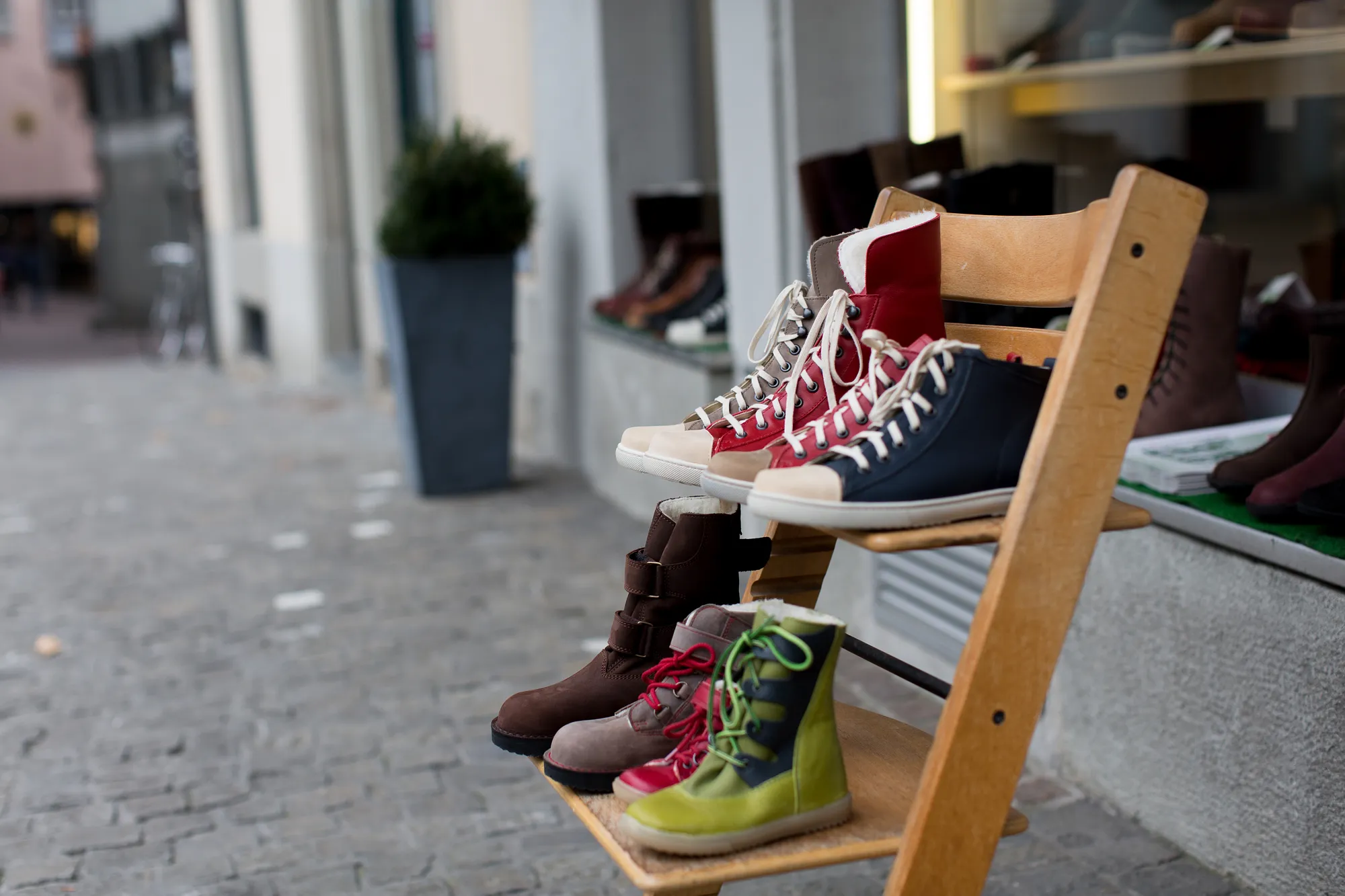 An image of a few pairs of shoes on a shoe rack, which the author akins it to observe others' shoes metaphorically in this article.