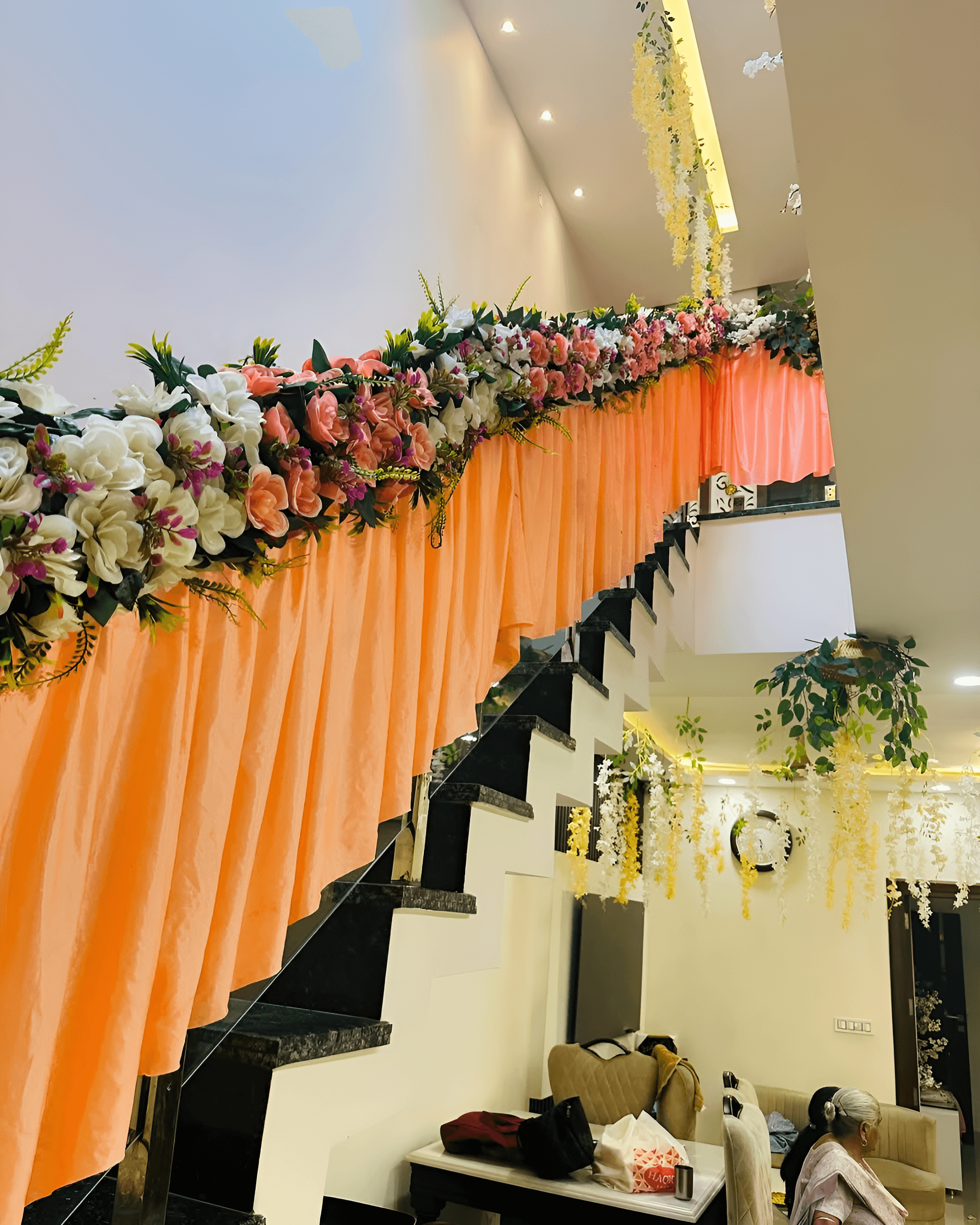Staircase decorated with peach drapes & flowers for stylish home wedding decoration in Janakpuri, Saket, Pitampura & Gurgaon.