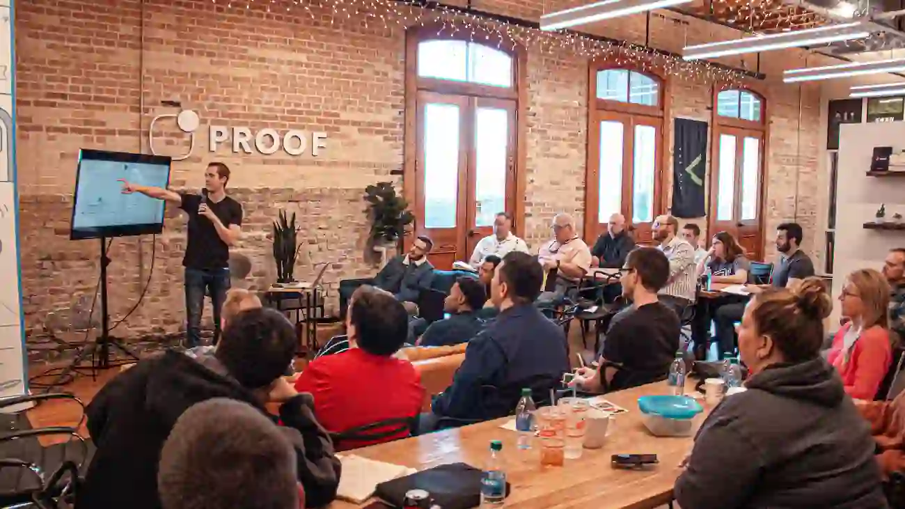 Speaker presenting to an audience in a workshop setting, representing a sports club sponsorship deck, pitch presentation and professional sponsor communication.