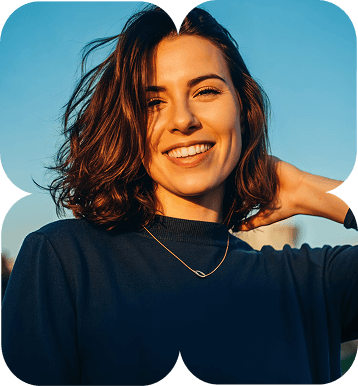 a woman with short brown hair wearing a navy-blue t-shirt with a small neckless and smiling looking front