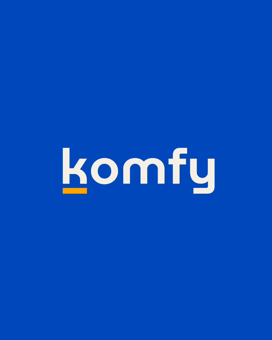 The image displays a minimalist blue background with the word "Komfy" written in a clean, modern white font, featuring a yellow accent under the letter 'k', symbolizing comfort and style branding.