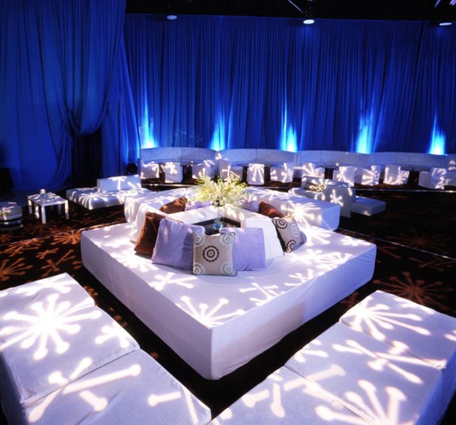 Elegant DJ booth with modern lighting and professional audio equipment set up for a corporate event.