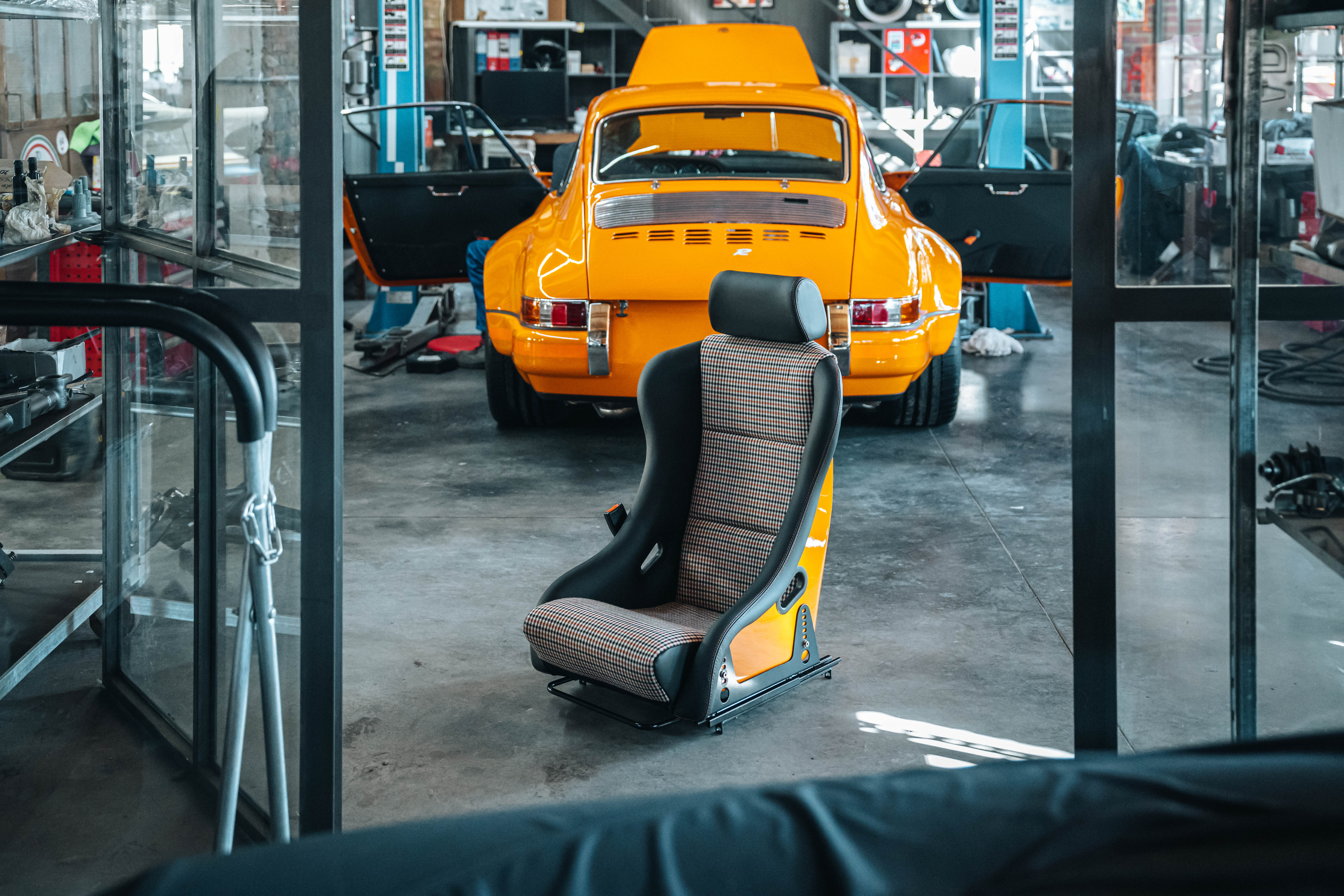 Foto di sedile da corsa Porsche di fronte a porsche arancione