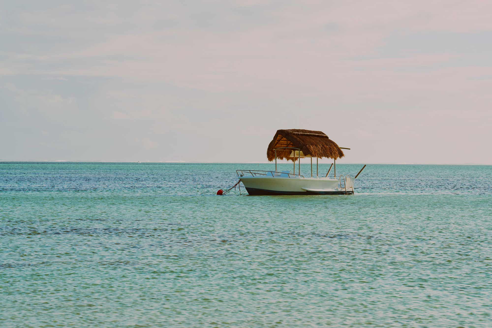 Boat floats on serene sea, filmproduction ad for a hotel in mauritius