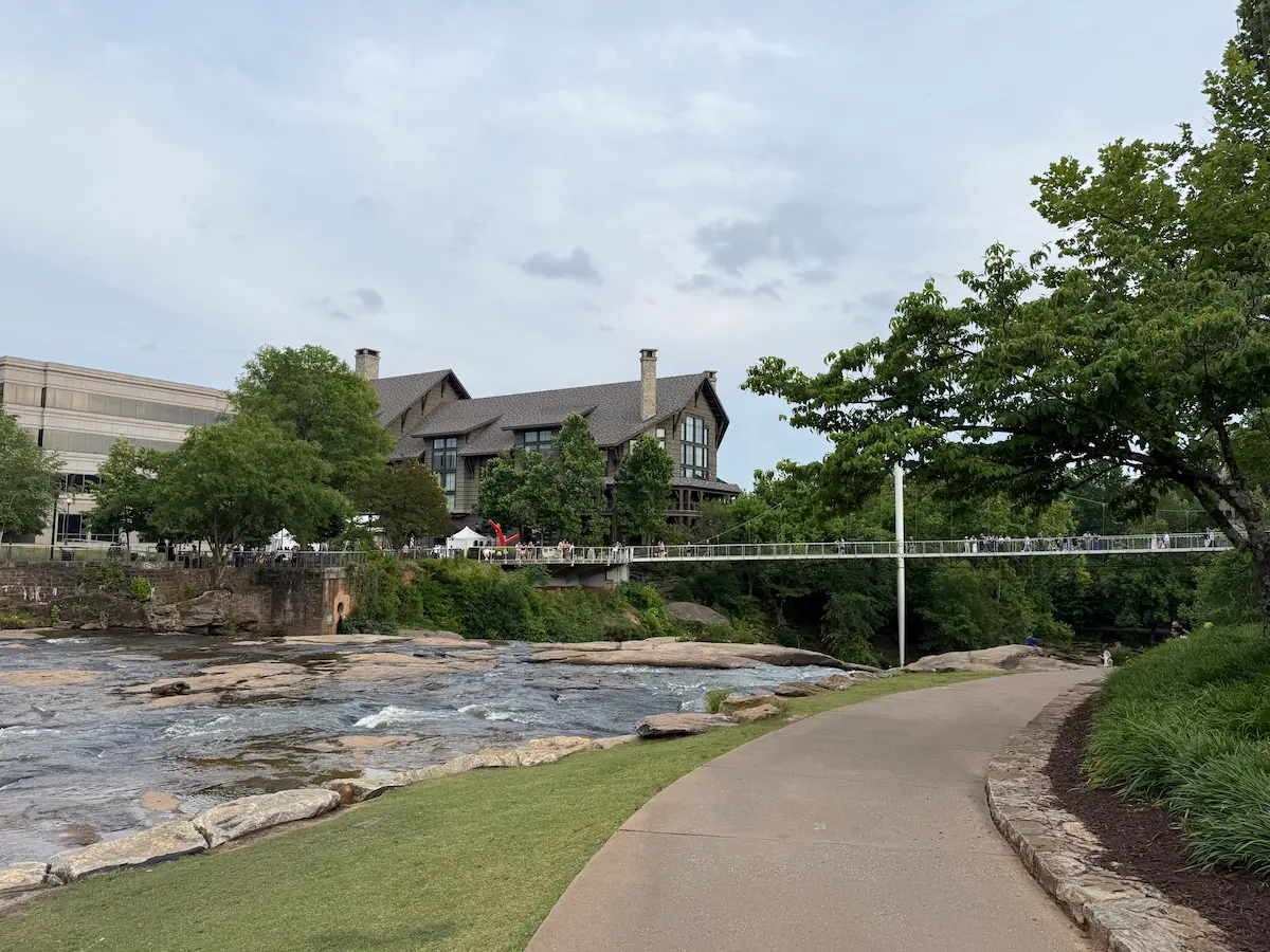 Walking path through Falls Park in Greenville, South Carolina, beneath a cloudy evening sky.