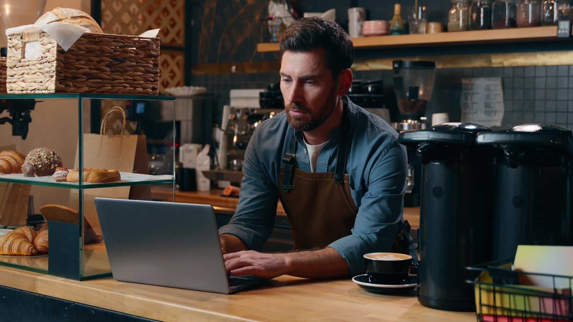 Pensive Caucasian entrepreneur barista employee male browsing Internet