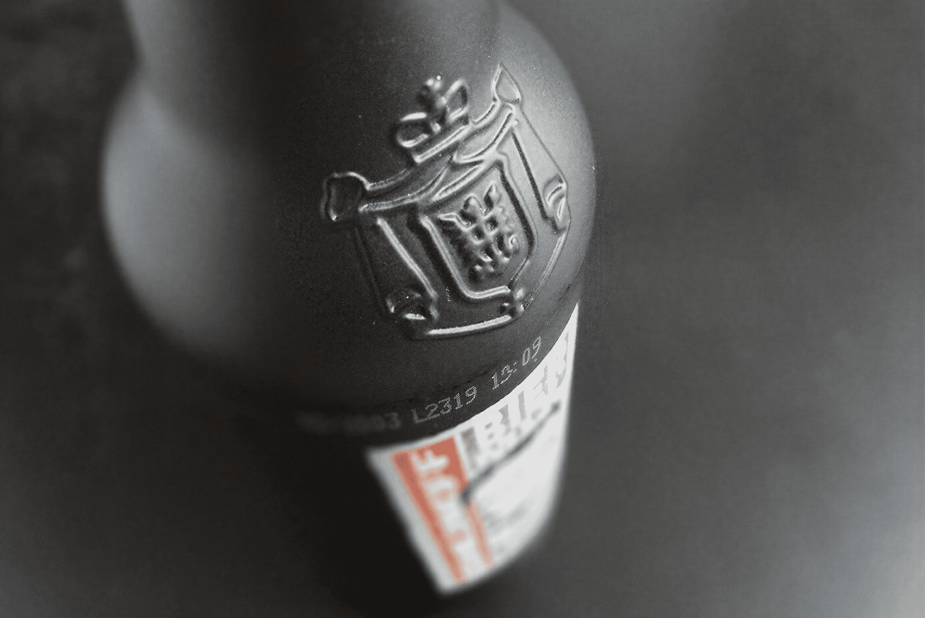 Embossed crest and date code on bottle