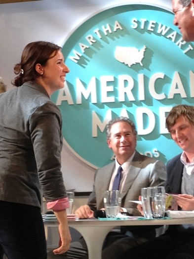 image of a few people in the frame and on the wall is a logo of Martha Stewart american made awards