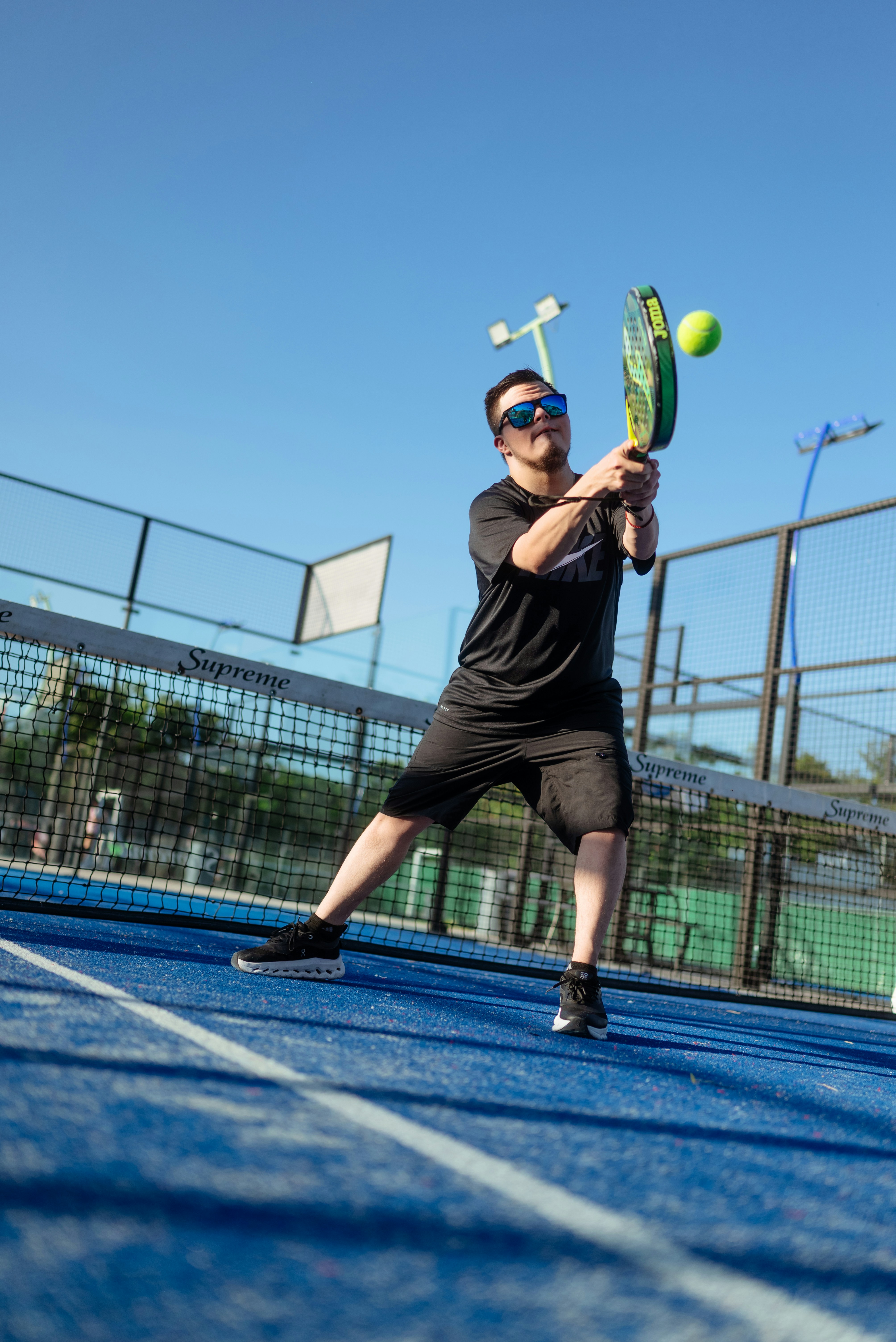 A man plays tennis, hitting the ball.