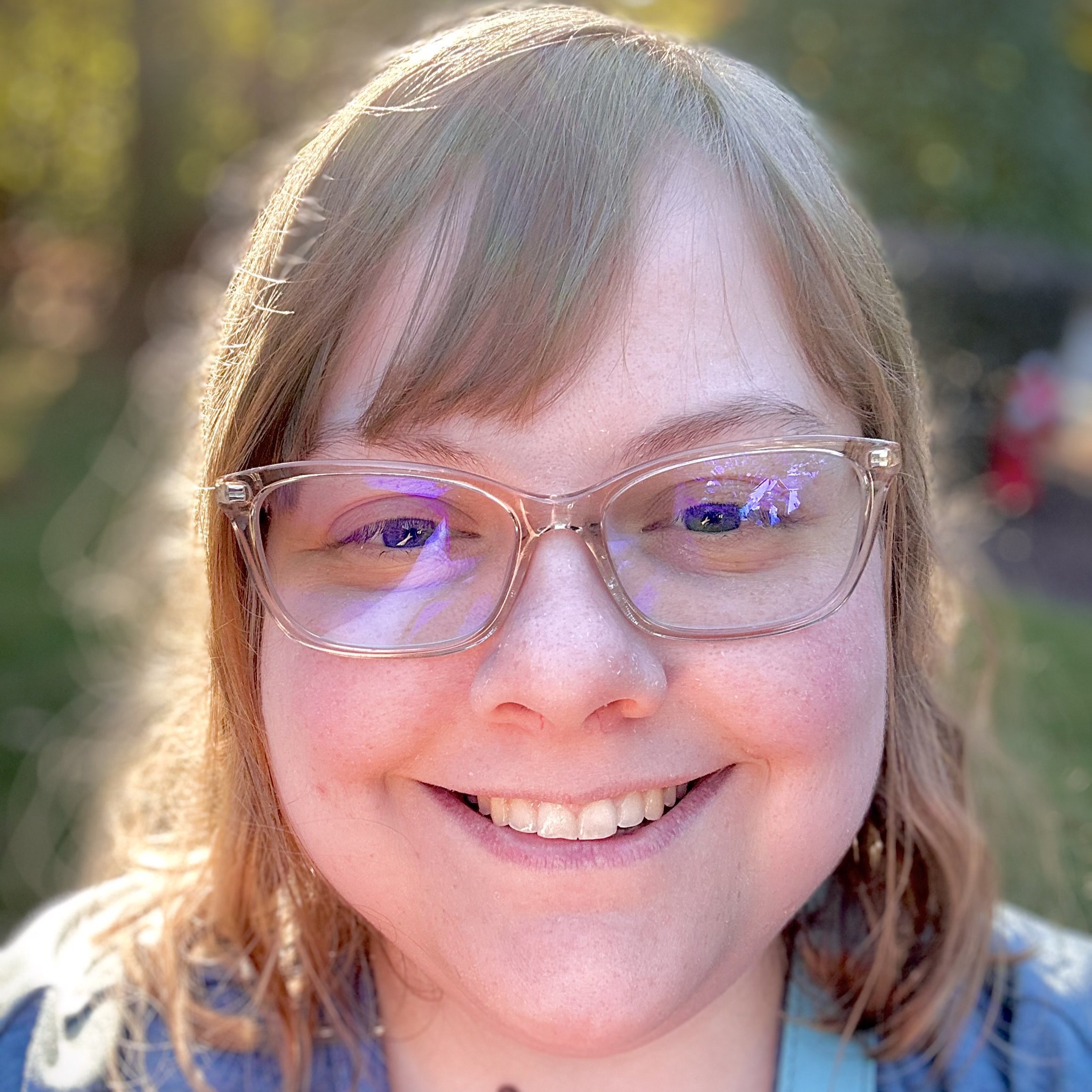 Portrait photo of Anna Babb, smiling and wearing glasses, taken in 2021.