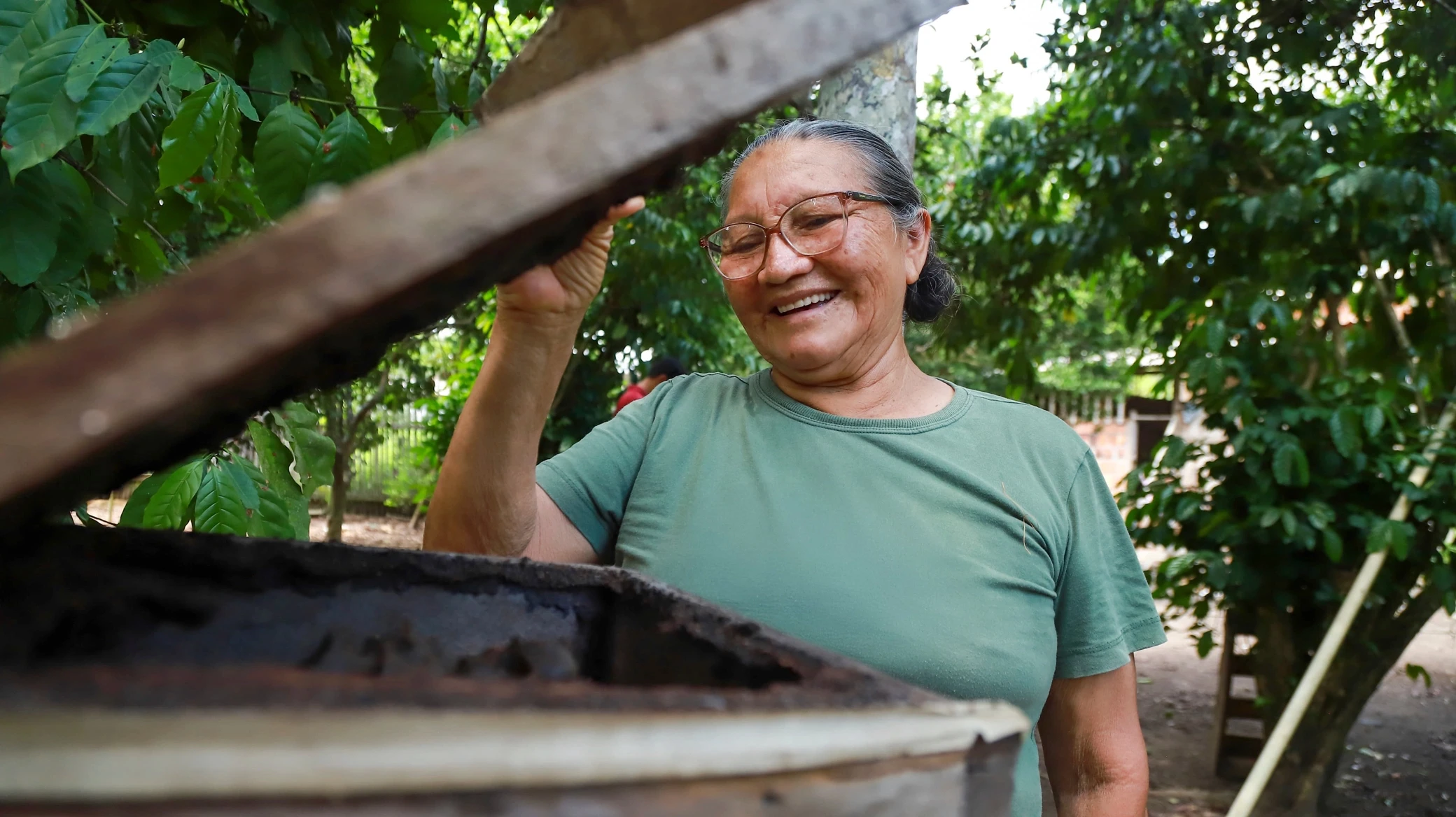 Mulher sorrindo enquanto abre uma melgueira.