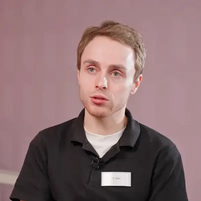 a man with a goatee smiles at the camera