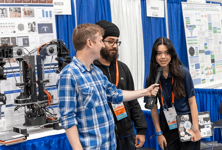 two isef contestants pitching their project into a microphone. Picture taken at ISEF