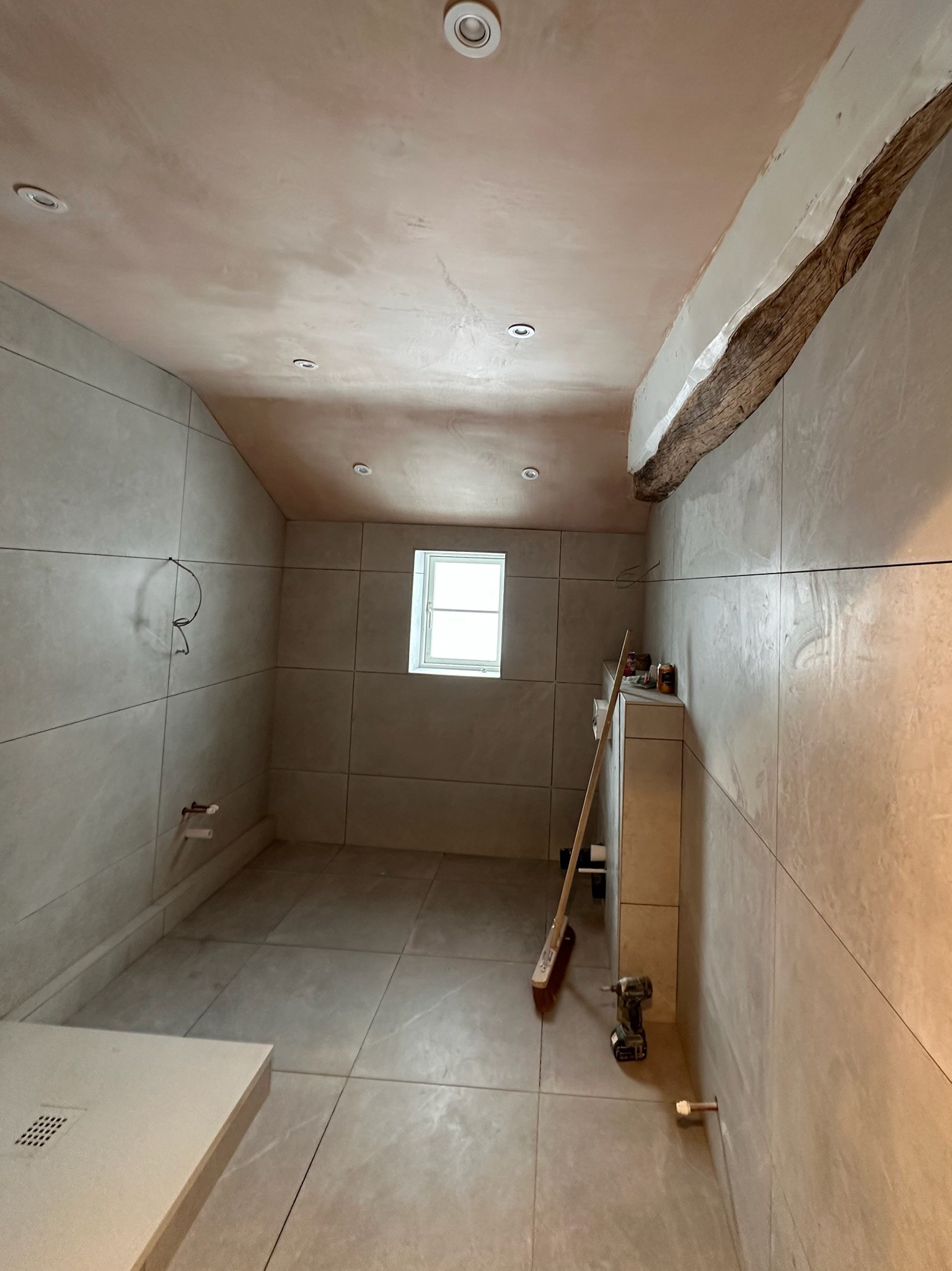 Plastered bathroom with vaulted ceiling.