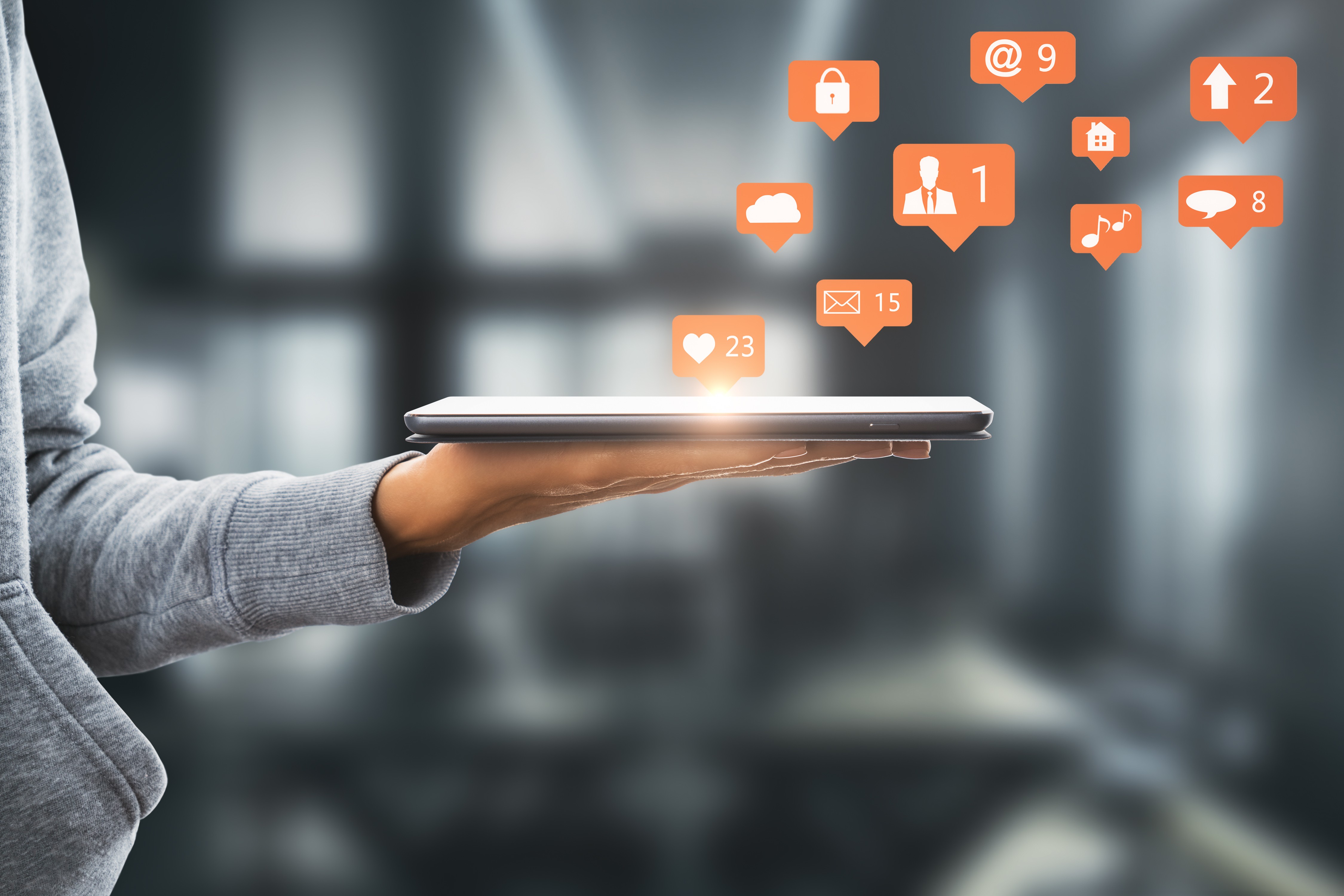 Man wearing an olive green jacket and black shirt, sitting and smiling in front of a light wooden background.