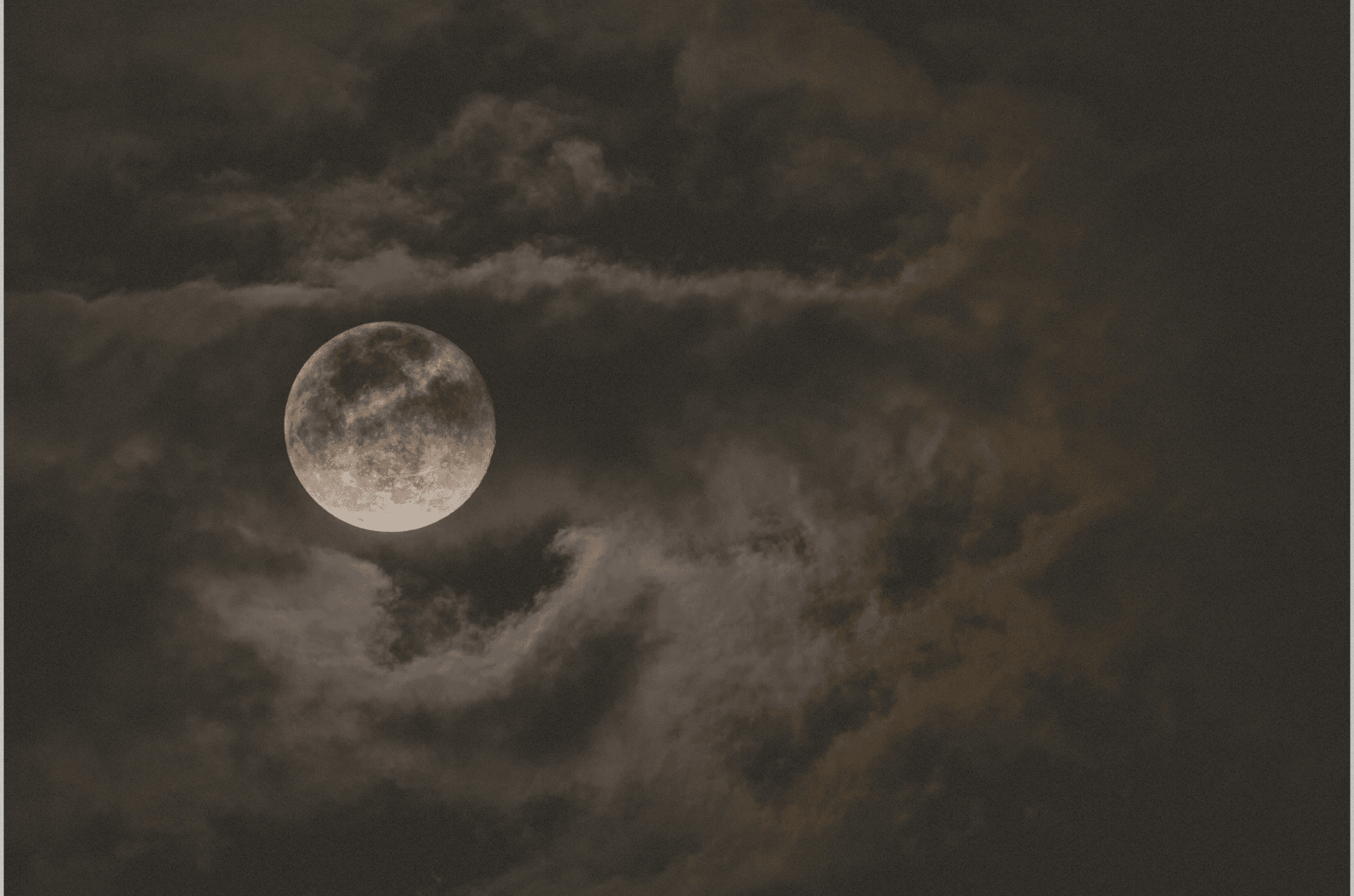 dark photo of night sky with clouds and a full moon