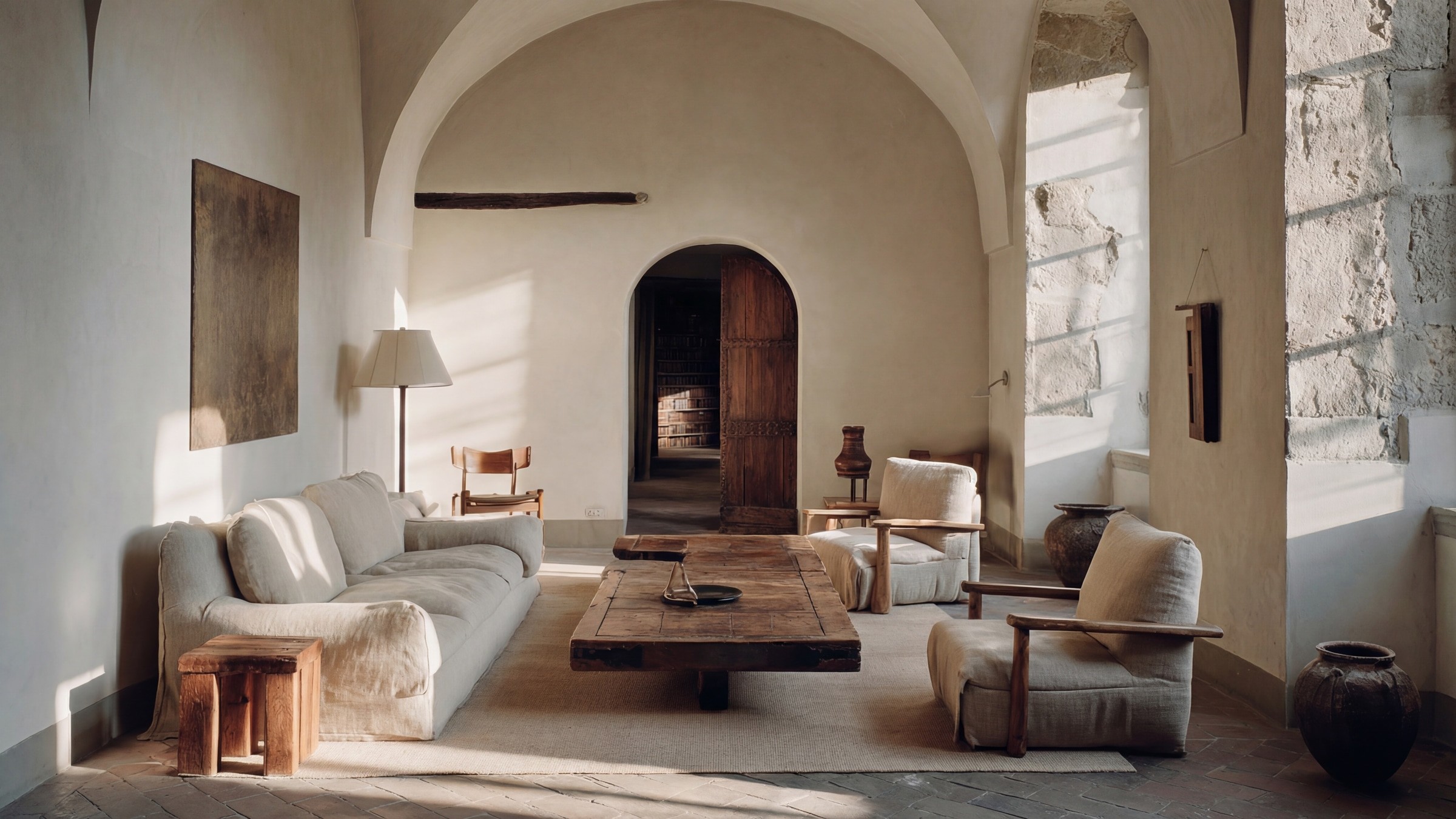 Ambiente in contesto storico con arredi essenziali, aperture ad arco e luce naturale.