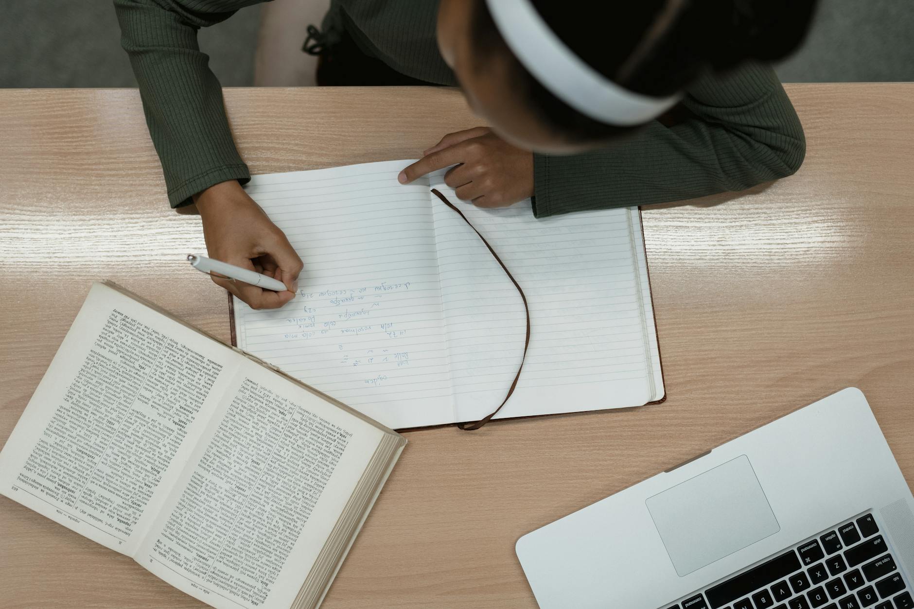 High school football player recording athletic statistics in a notebook