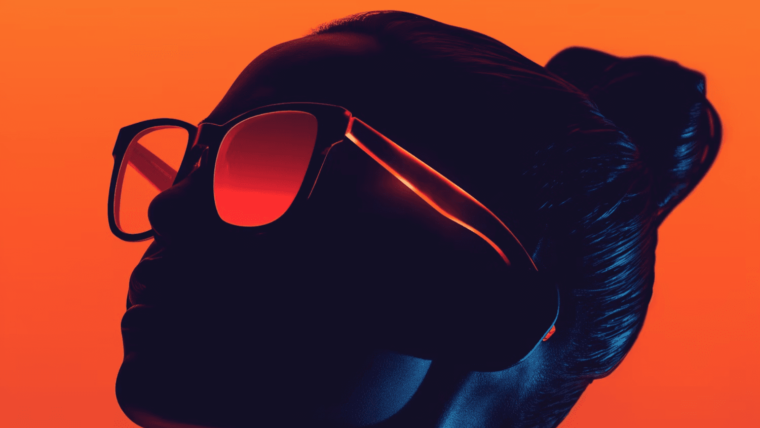 Silhouette of a person wearing red-orange sunglasses on orange.