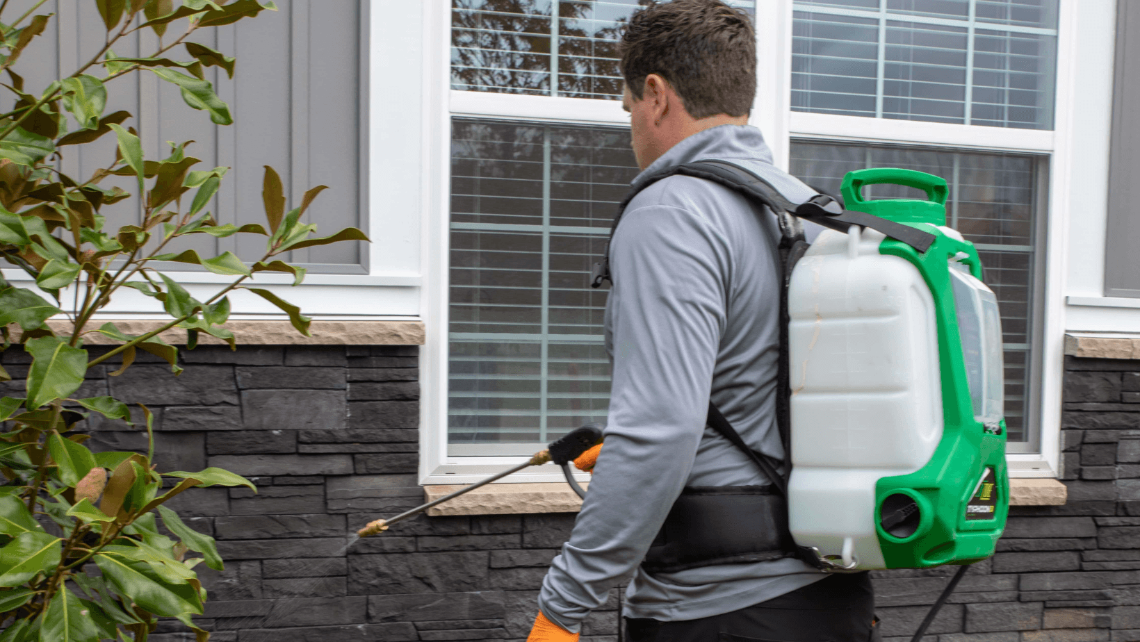 A technician applies an outdoor pest treatment