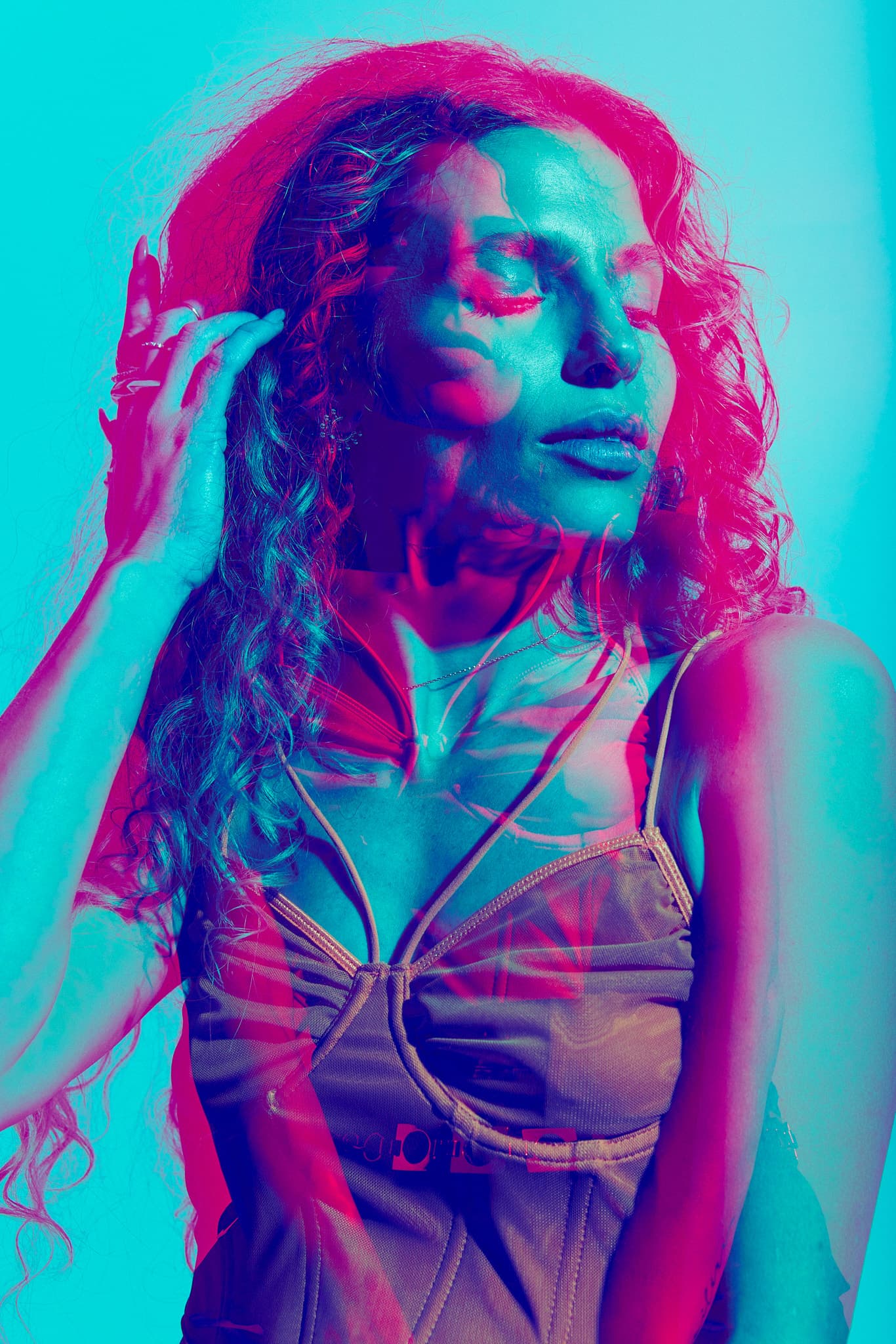 A close-up of the model’s face with red and blue light overlays, creating a surreal effect at Revelator Studio, a Shreveport natural light photography studio.