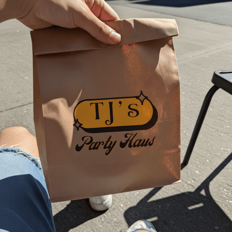 Image of golden balloons with a bunch of colorful confetti falling in front of them.