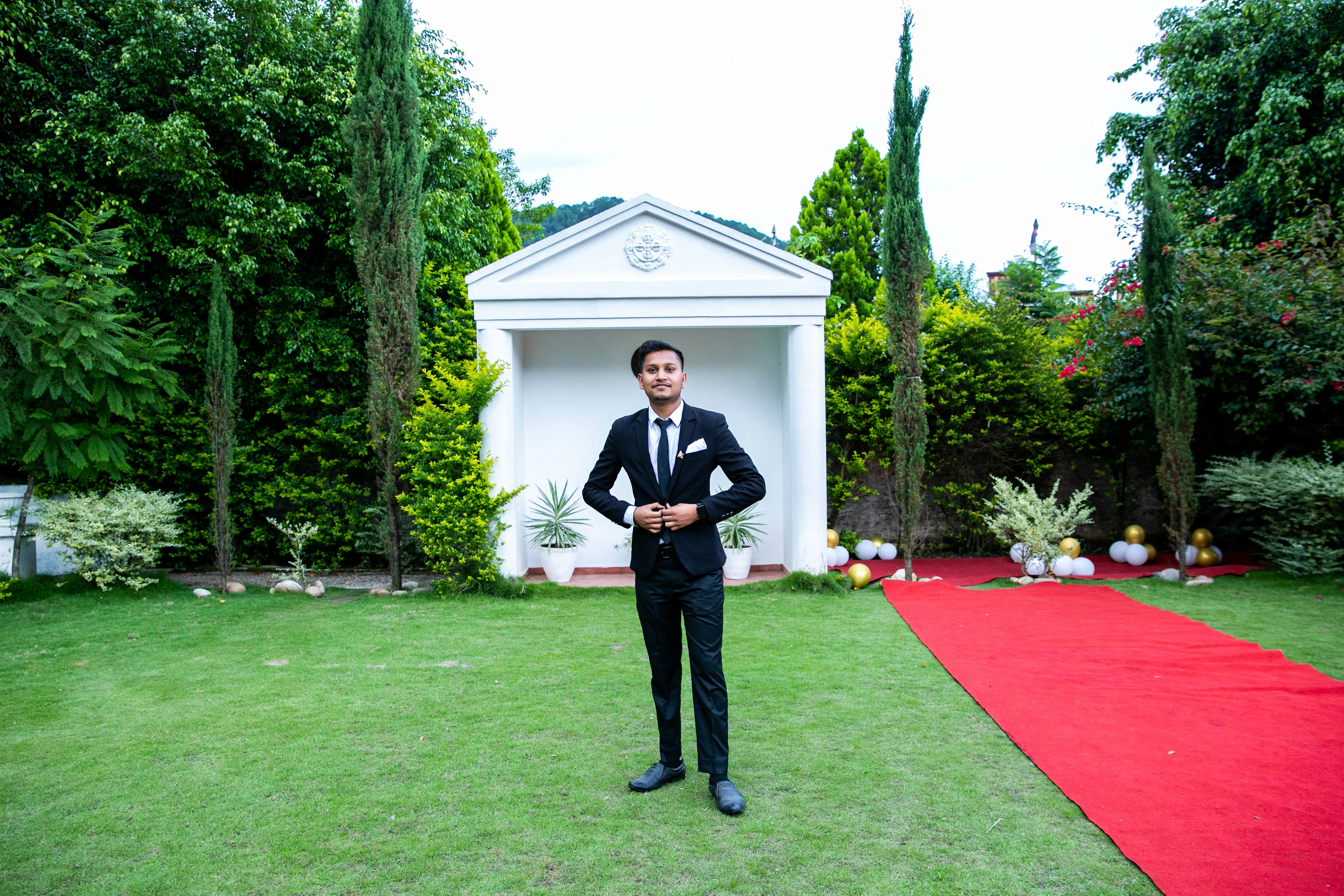 Trimmed black suit on young man in garden