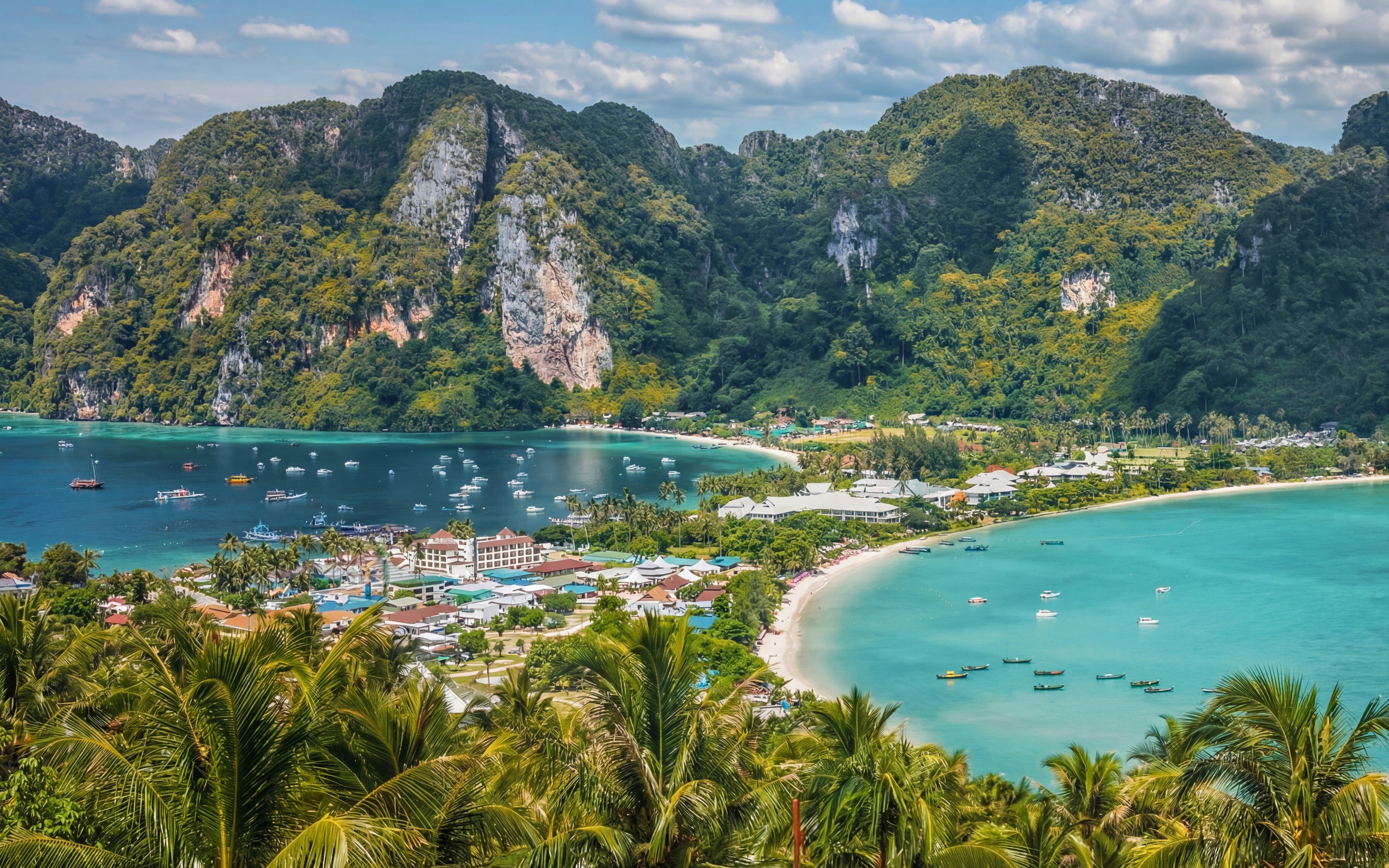 Aerial view of Ao Nang in Krabi, Thailand, showing limestone cliffs, palm-lined beaches, turquoise bays, and the coastal town.