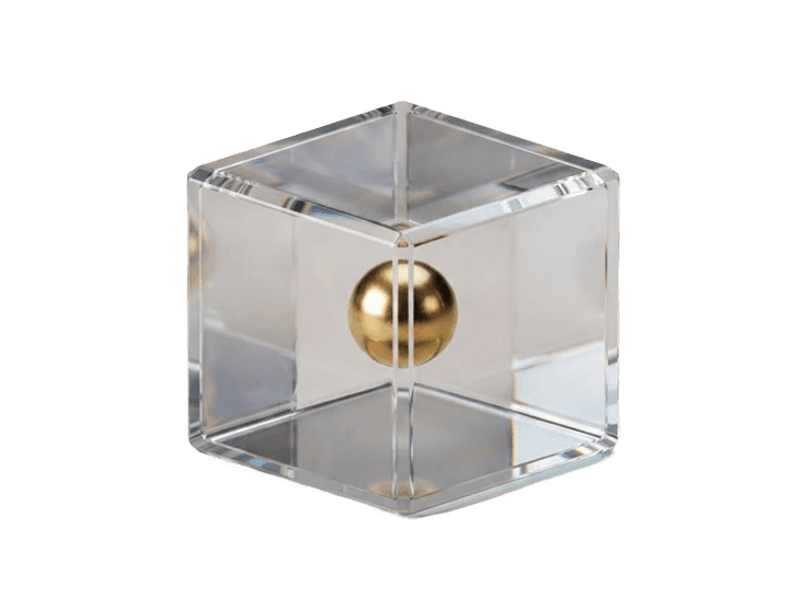 Small glass cube with a gold sphere embedded at its center, on a black background.