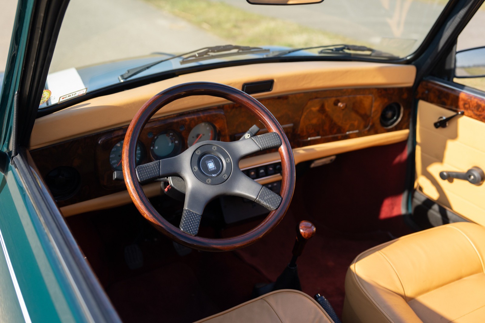 Classic car interior showcasing a wooden dashboard and a stylish steering wheel.