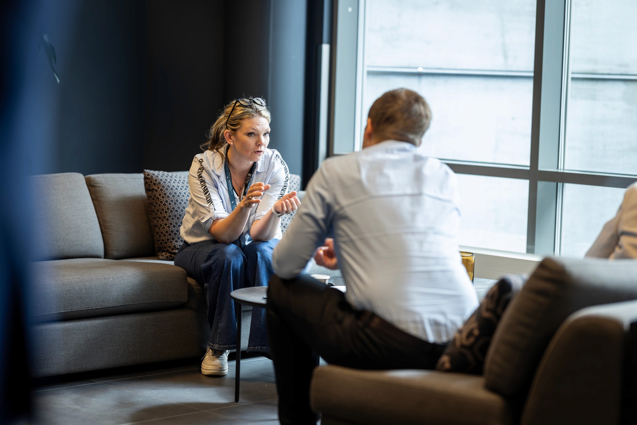 A group of people mingling at an event, with one man looking upwards, appearing deep in thought.