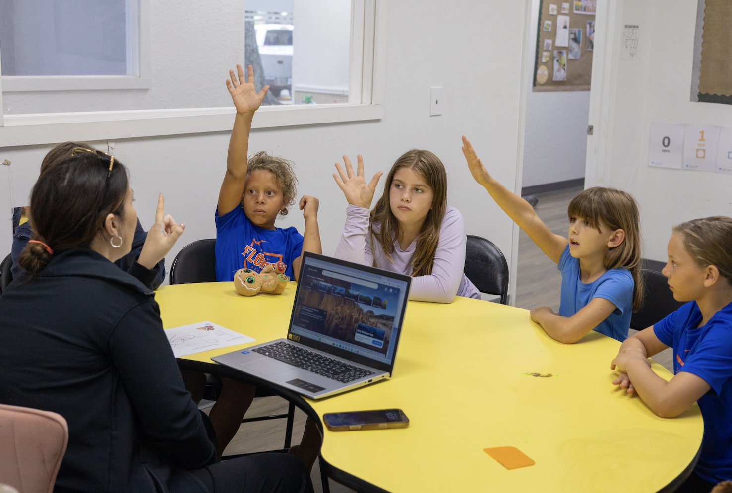 Children engaging with a teacher in a child-friendly classroom moment