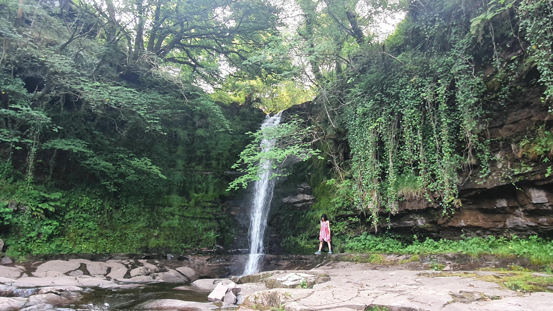 Samira standing by a waterfall