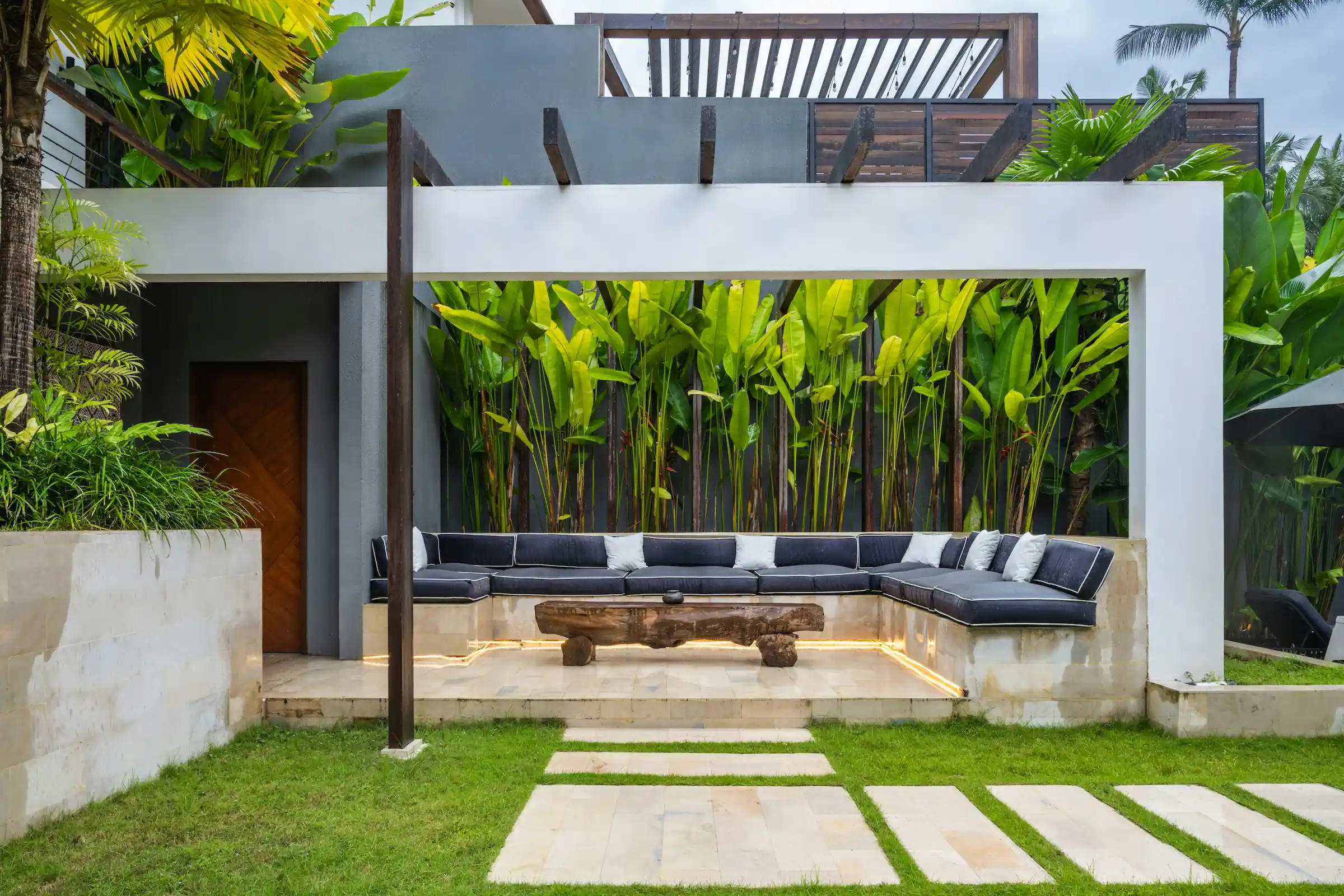 Minimalist living space featuring oak flooring, timber wall panels and panoramic windows with natural light.