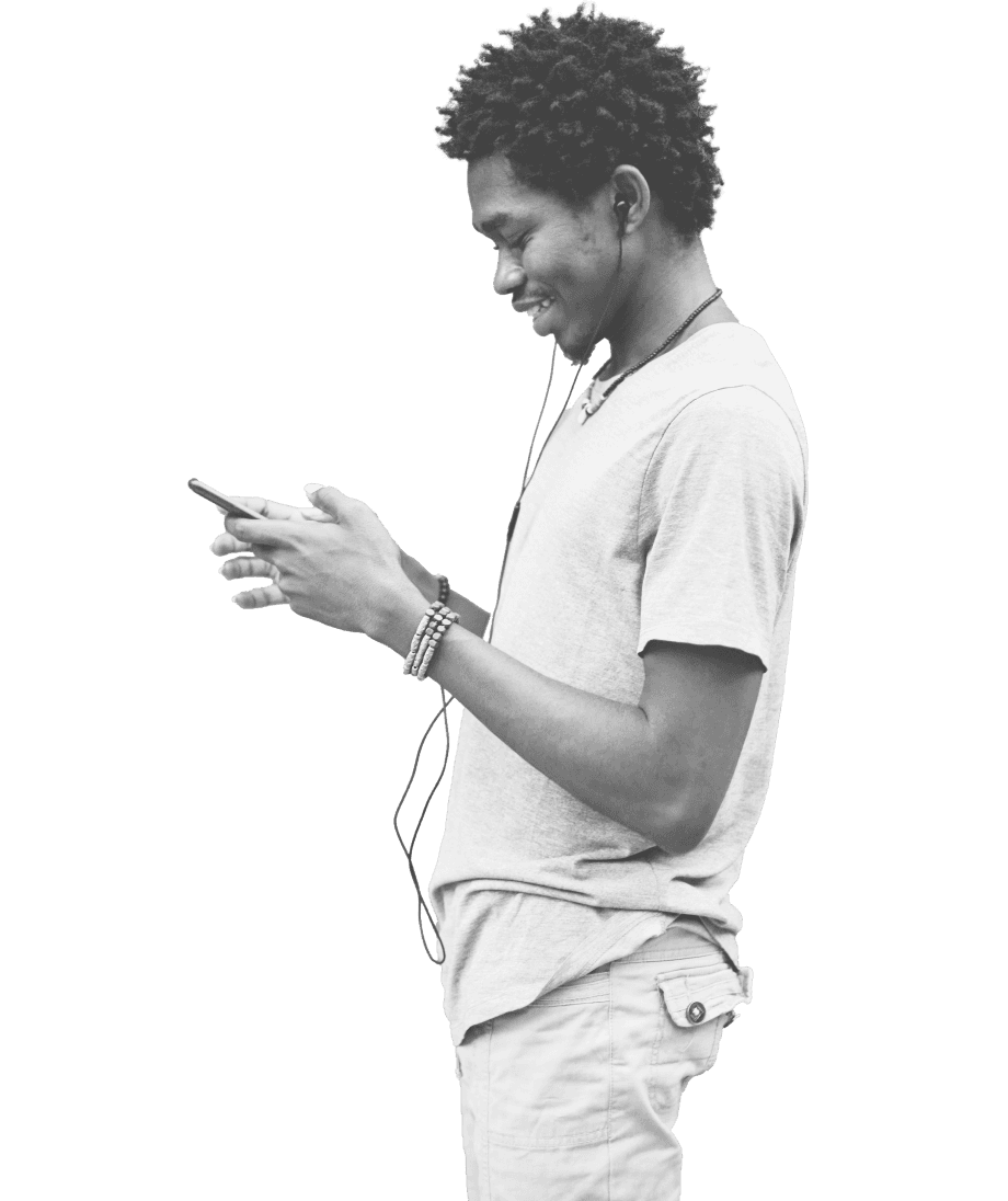 A young person wearing casual attire, including a t-shirt and shorts, smiles while looking at their smartphone, with earphones plugged in, suggesting engagement with mobile forex trading activities.