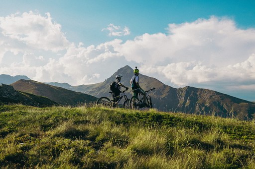 Two bikers in front of Gjeravica peak in Kosovo, mountain biking