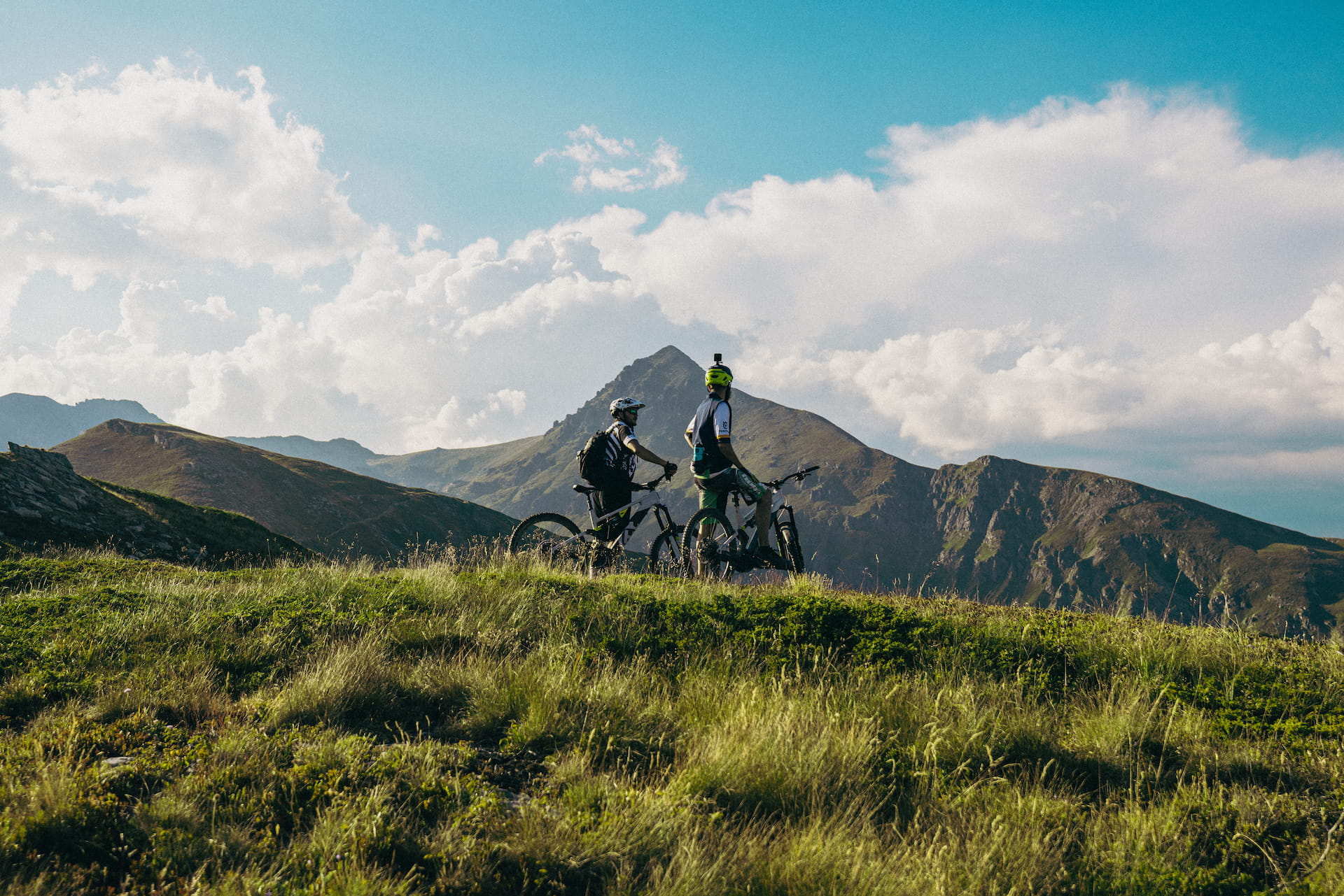 Two bikers in front of Gjeravica peak in Kosovo, mountain biking