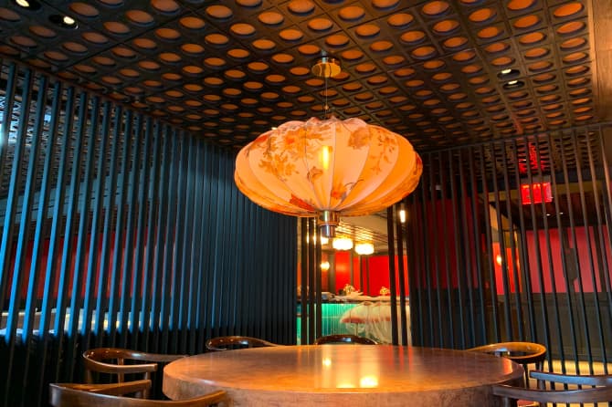 Hanging lantern over a table with a dark pattern on the ceiling