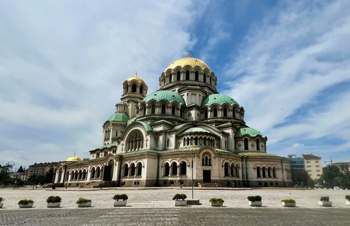 A large building with a green roof and gold domes