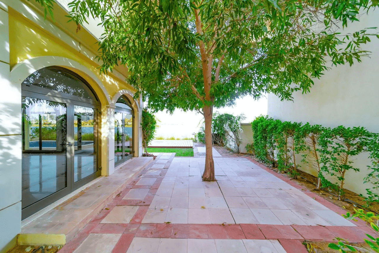 A spacious house with steps descending to the beach, nestled among charming garden homes.