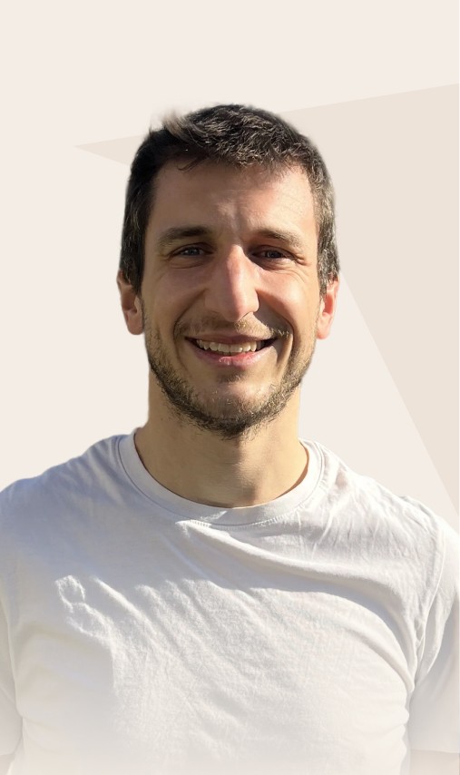 Portrait d'un homme souriant dans un t-shirt blanc avec un fond naturel.