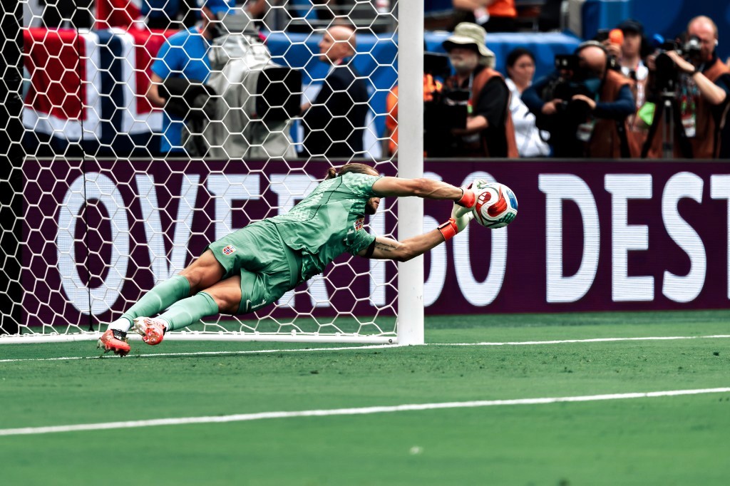 Norway goalkeeper Orjan Nyland dives to catch the ball during a spectacular save against Brazil
