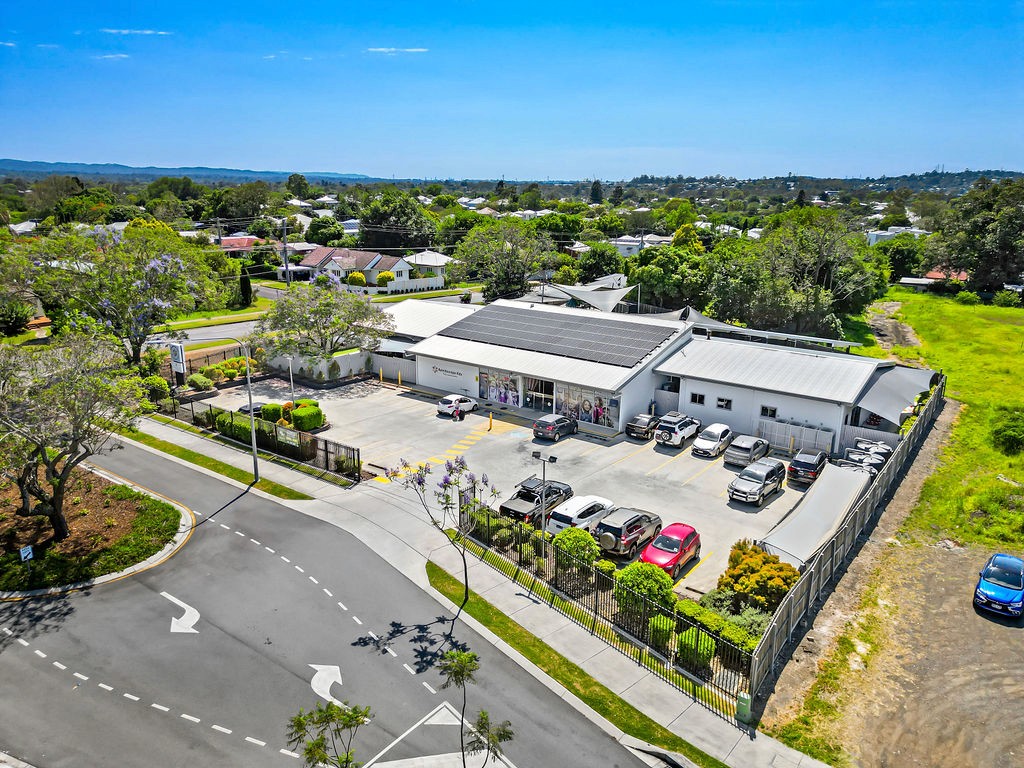 Front entrance of Kaleidoscope Kids Booval childcare centre with street signage at 6 Butter Factory Road and on-site parking visible.