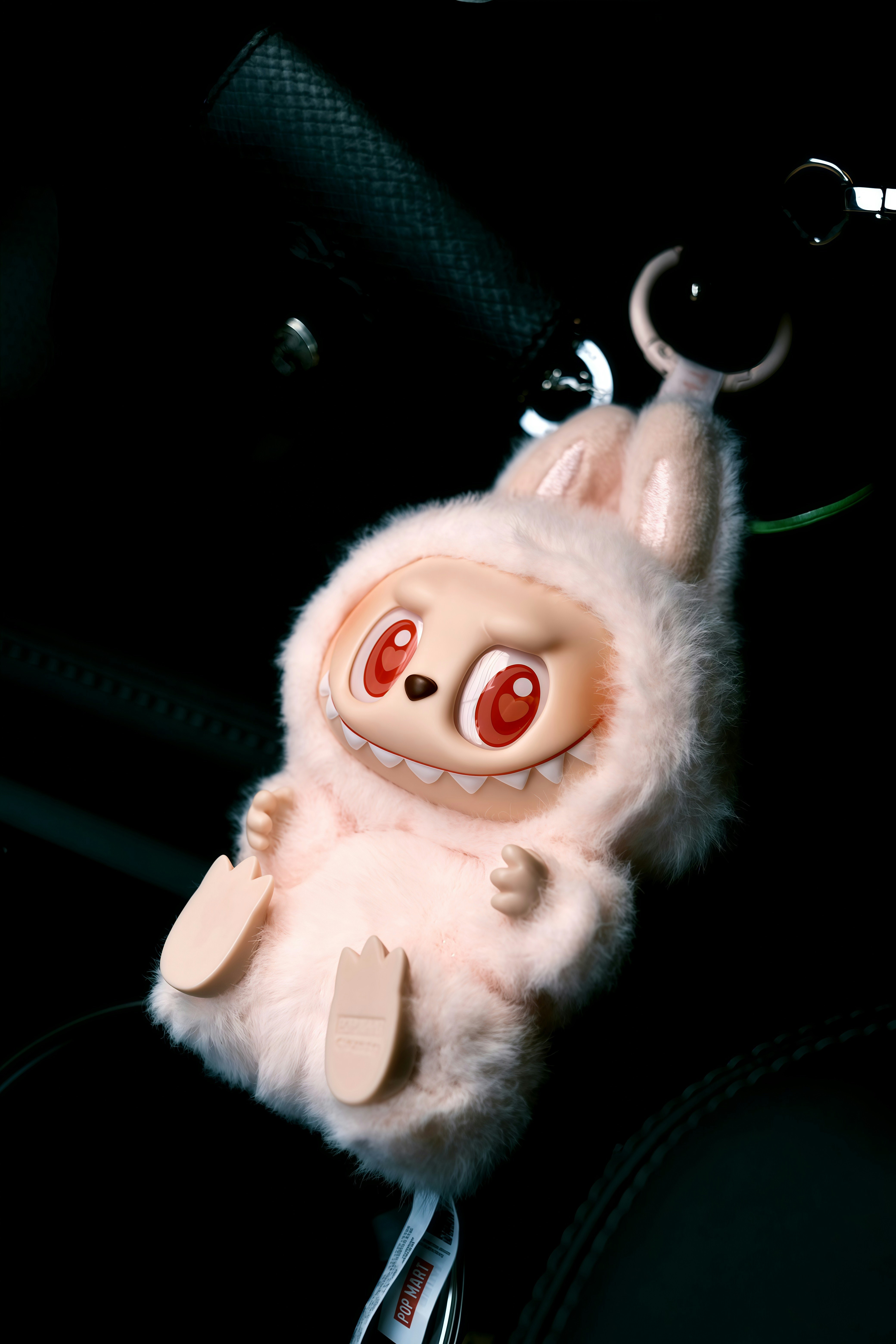 Fluffy pink monster toy with big red eyes.