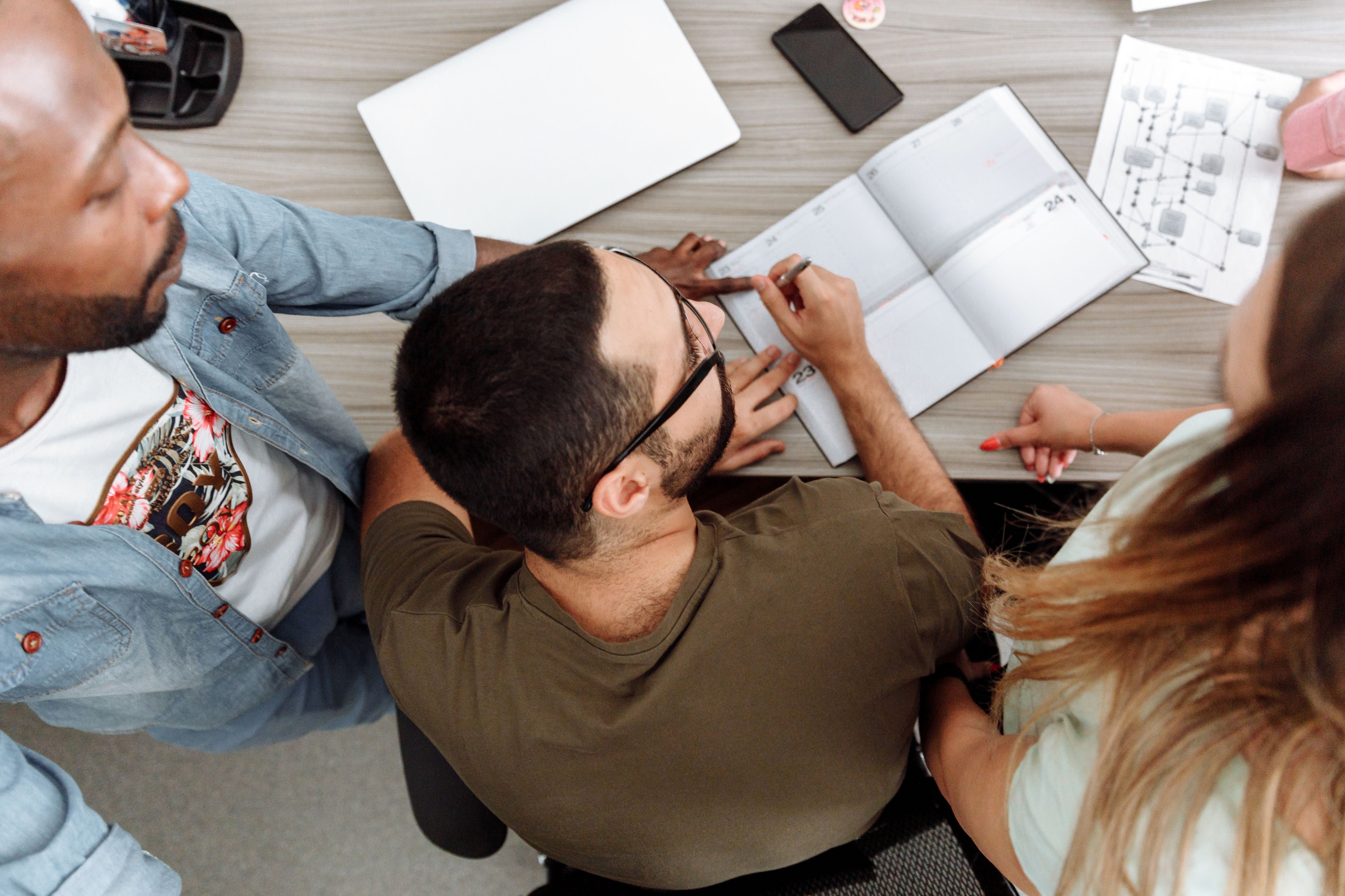 Overhead view of a diverse team collaborating around a desk in a modern office.