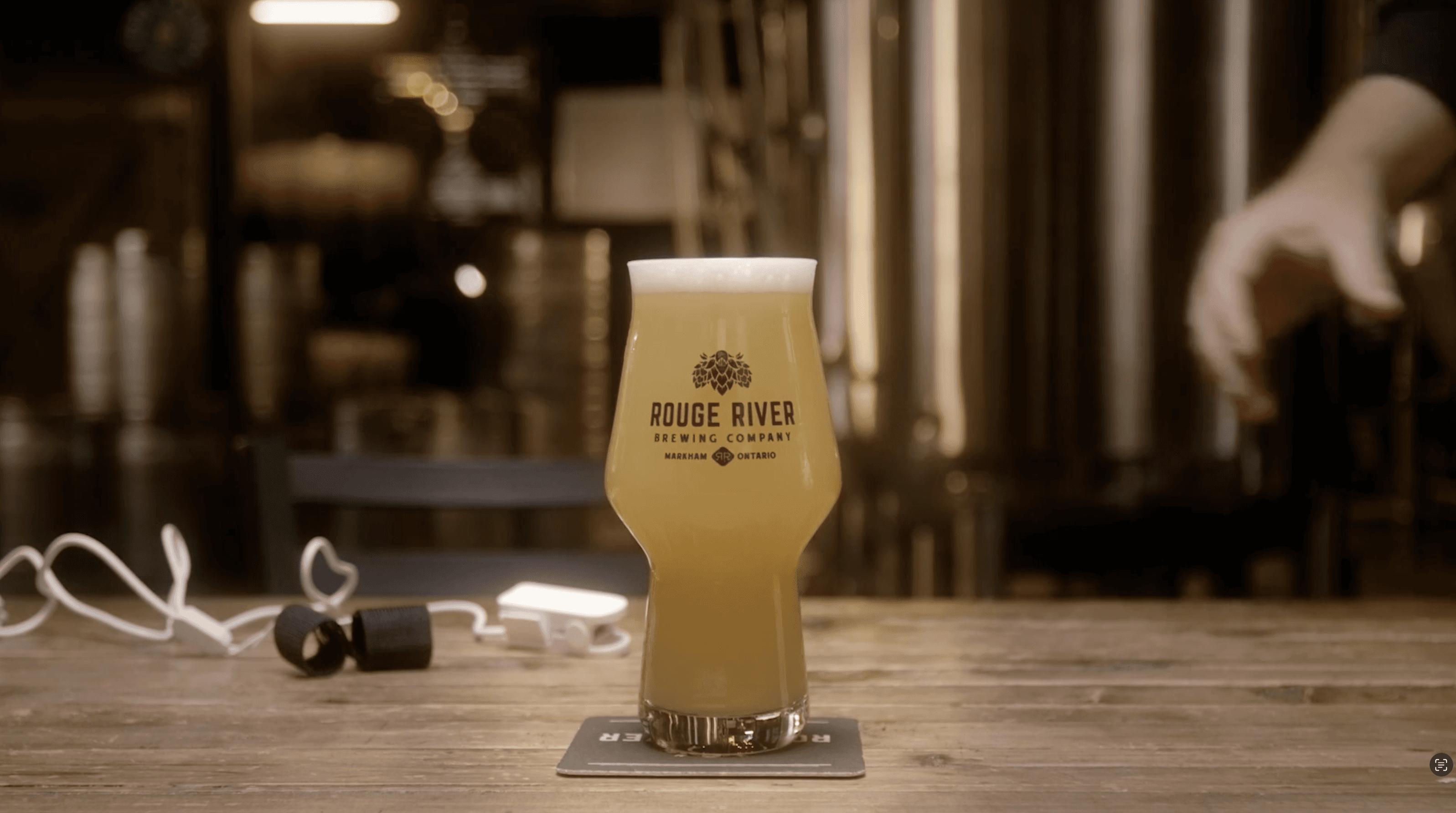 Close-up of a yellow tennis ball sitting on a green court, positioned near the white center line.